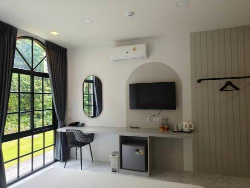 a living room with a television and a desk with a chair at The Target Hotel chaingrai in Chiang Rai