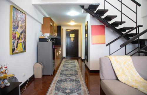 a living room with a couch and a staircase at Raffy White Boracay in Boracay