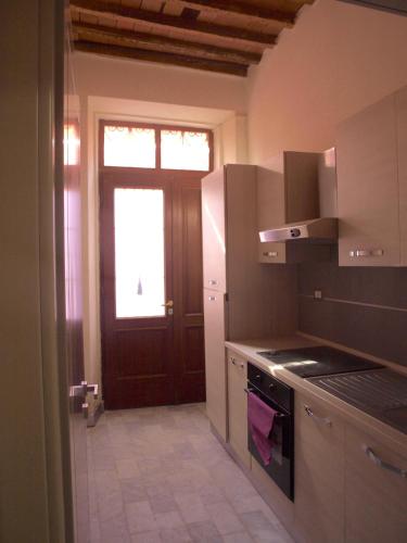 a kitchen with a stove and a window and a door at Ostello Palazzo Nizza in Massa