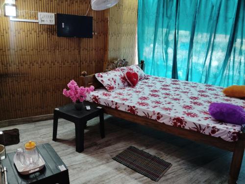 a bedroom with a bed and a table with flowers at MAMATA CROWN Inn in Bhubaneshwar