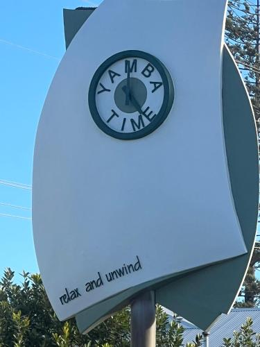 a clock on a pole in front of a building at Lakeview Yamba River Side Waters in Yamba