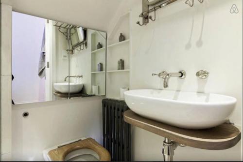 a bathroom with a sink and a toilet at Retreat to a Stylish 1 Bedroom Flat in Chelsea in London