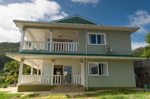 a green house with a balcony on top at Villa Kayola - Self Catering in Mahe