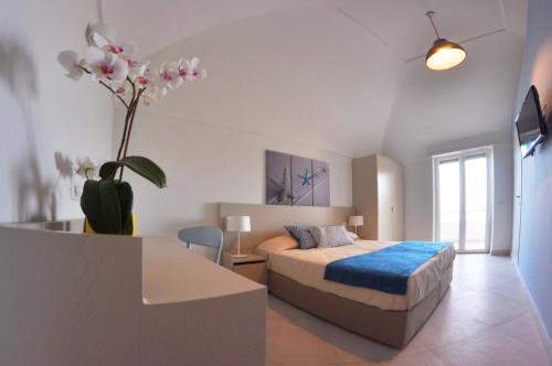 1 dormitorio con 1 cama y un jarrón con una planta en Casa Costanza, en Capri