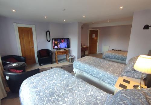 a hotel room with two beds and a flat screen tv at Marie's Bed and Breakfast in Coolock