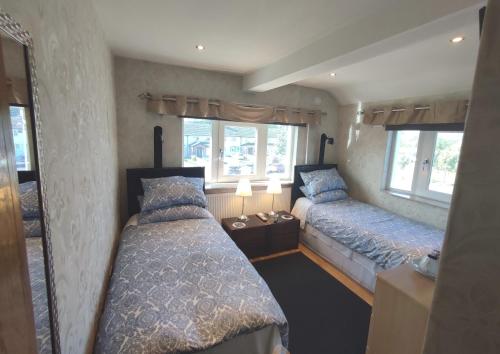 a bedroom with two beds and two windows at Marie's Bed and Breakfast in Coolock