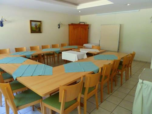 a classroom with wooden tables and chairs and a whiteboard at Landgasthof-Hotel-Rössle in Oberprechtal