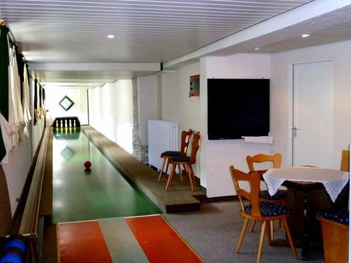 a room with a bowling alley and a table and chairs at Landgasthof-Hotel-Rössle in Oberprechtal