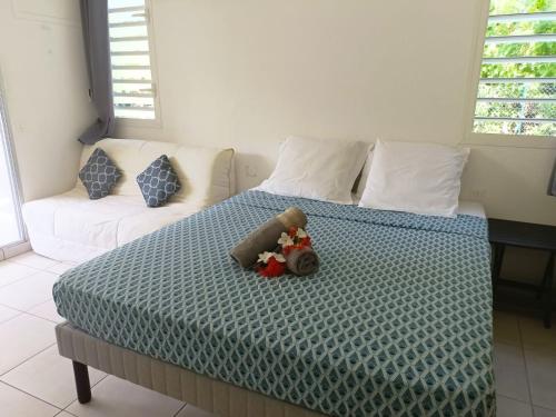 a bedroom with a bed with a stuffed animal on it at Tidousè Matnik in Sainte-Anne