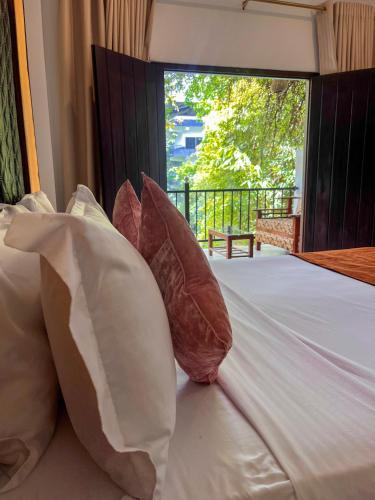 a bed with pillows and a window in a room at Sundaras Infinity Jungle Resort in Dambulla