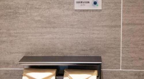a table with two chairs in front of a wall at Atour Hotel Jinan Tangyan Century Avenue in Jinan