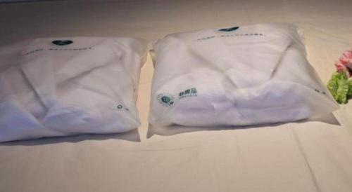 two white towels sitting next to each other on a table at Atour Hotel Jinan Tangyan Century Avenue in Jinan