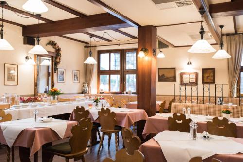 um restaurante com mesas, cadeiras e janelas em Gasthaus Zum Specht em Hösbach