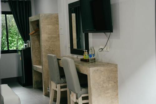 a kitchen with a table with chairs and a mirror at The Target Hotel chaingrai in Chiang Rai