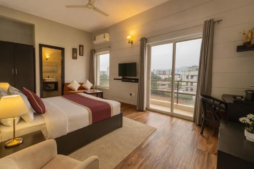 a hotel room with a bed and a large window at The Sapphire Resort 1,2,3 bedrooms villas available in omaxe vrindavan - A Four Star Luxury Resort in Vrindāvan