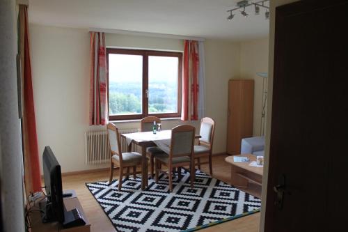 een eetkamer met een tafel en stoelen en een raam bij Appartementhaus Karawankenpromenade in Velden am Wörthersee