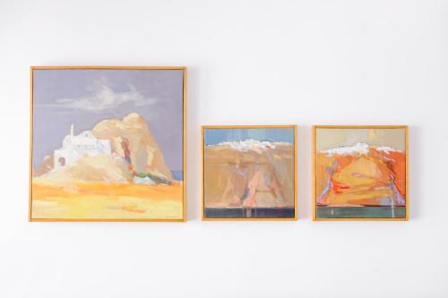 a group of four paintings on a wall at Aria Suites & Villas in Fira