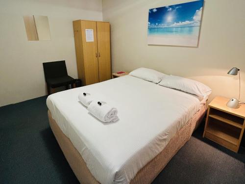 a hotel room with a bed with towels on it at Siesta Sydney in Sydney