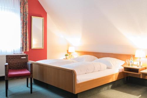 ヘスバッハにあるGasthaus Zum Spechtの赤い壁のベッドルーム1室(大型ベッド1台付)