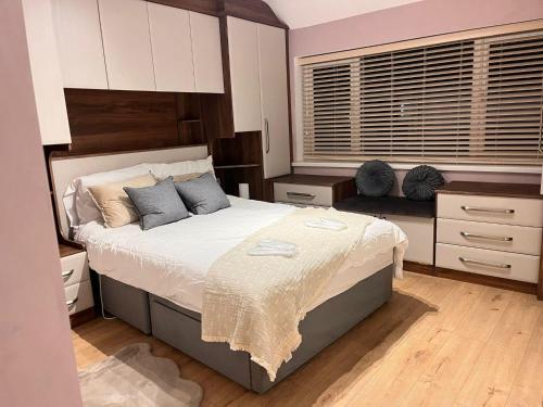 a bedroom with a large bed with blue pillows at 3Bedroom-Sleeps5-WiFi-SingleCarParking in Wythenshawe