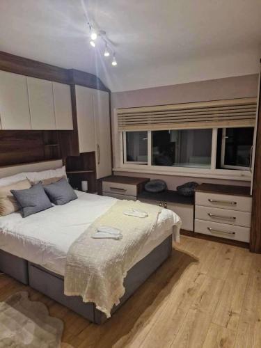 a bedroom with a large bed and two windows at 3Bedroom-Sleeps5-WiFi-SingleCarParking in Wythenshawe