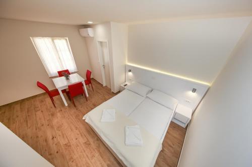 a room with a white bed and a table and chairs at Idassa Atrium rooms in Zadar