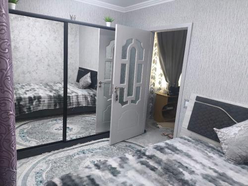 ein Schlafzimmer mit einem Bett und einer Tür mit einem Spiegel in der Unterkunft Miledi in Bălţi
