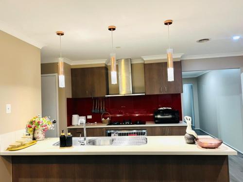 a kitchen with red walls and a white counter top at Tarneit Treasure in Tarneit