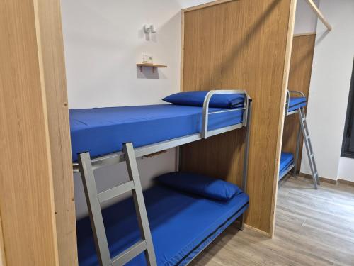 a room with two bunk beds with blue pillows at Albergue Camino Espiritual in Ribadumia