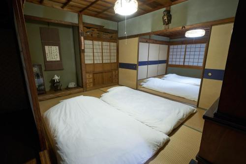 two beds in a room with two mirrors at Song Yin Pavilion / Vacation STAY 78854 in Shimosato