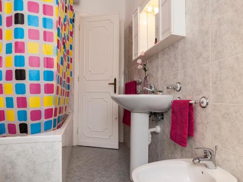 een badkamer met een wastafel, een toilet en een spiegel bij Casa Scilla in Sperlonga
