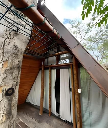 a treehouse with awning and sliding glass doors at Espaço Gaia in Santana do Riacho