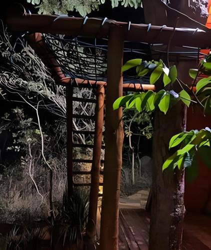 a pergola with a bird cage in a garden at Espaço Gaia in Santana do Riacho