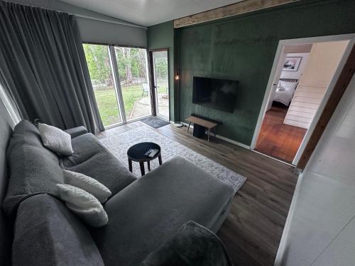 a living room with a couch and a television at Kookaburra Retreat in Daylesford