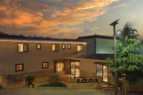 a large building with a sunset in the background at Zemulong Inn - Shangri-La, Dukezong Ancient Town, Moonlight Plaza in Shangri-La