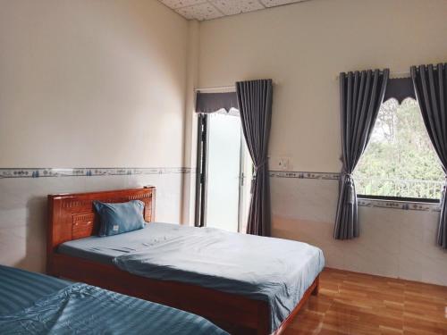a bedroom with two beds and a window at Đức Phát Homestay in Tân Phú