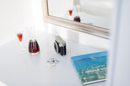 a table with glasses and a mirror and a book at Aria Suites & Villas in Fira