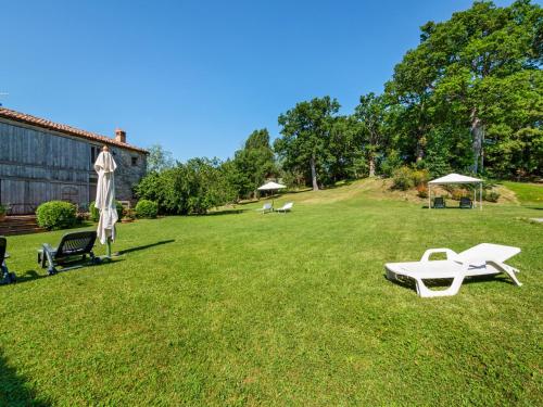 a lawn with two lounge chairs and an umbrella at Peaceful Getaway in Frontino in Frontino
