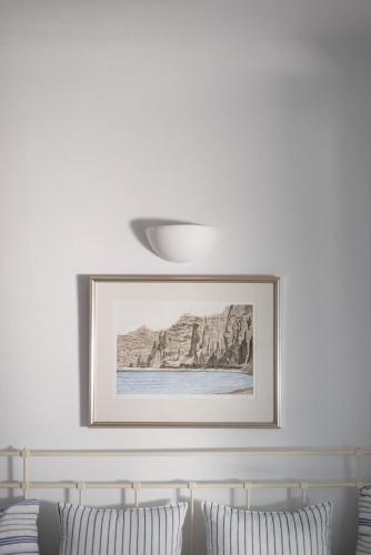 a picture hanging above a bed with two pillows at Aria Suites & Villas in Fira