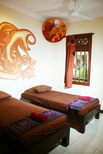 a room with two beds and a window at Hostel 1001 Malam Malioboro in Jetis