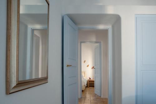 a hallway with a mirror and a bedroom at Aria Suites & Villas in Fira