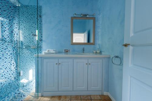 a bathroom with a sink and a mirror at Aria Suites & Villas in Fira