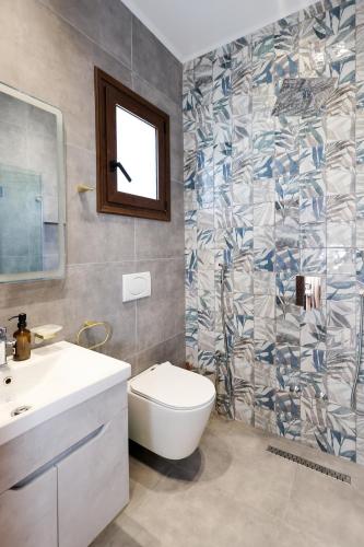 a bathroom with a toilet and a sink and a mirror at Villa Starova in Berat