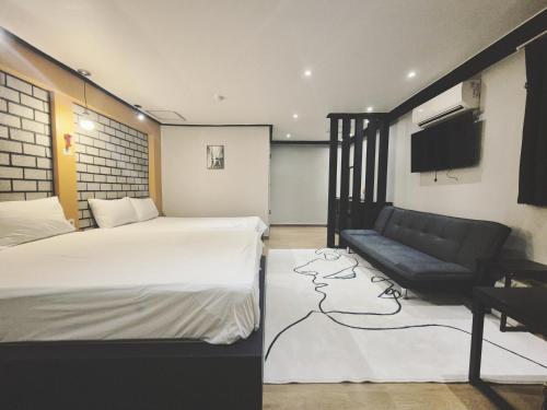 a hotel room with a bed and a couch at 안온호스텔 성수건대 in Seoul