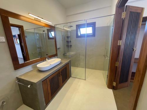 a bathroom with a sink and a glass shower at Tangalle Villa in Tangalle