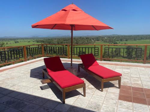 two chairs sitting under an umbrella on a patio at Tangalle Villa in Tangalle