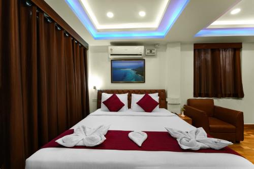 a bedroom with a large bed with red pillows at Adhvasaha Beach Spa Resort in Port Blair