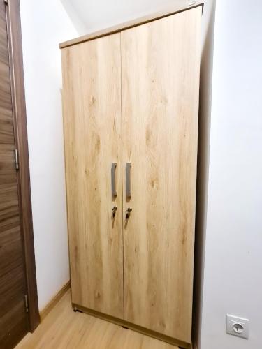 a wooden cabinet in a room with a white wall at Apt SKY house 2br cozy & family in Cisauk 1