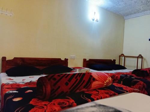 a bedroom with two beds with blankets on them at Silonya Forest Edge in Nuwara Eliya