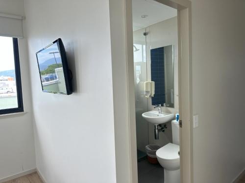 a bathroom with a toilet and a sink at Global Backpackers Cairns in Cairns